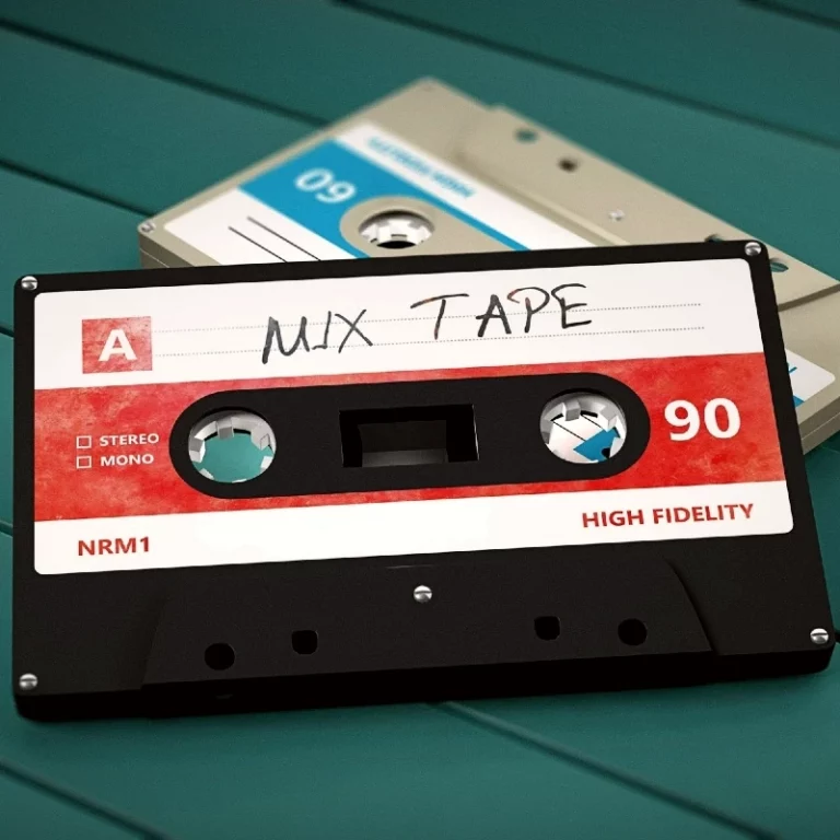 Zwei Audiokassetten liegen auf einer türkisfarbenen Holzfläche, die obere handbeschriftet mit dem Wort Mix Tape.