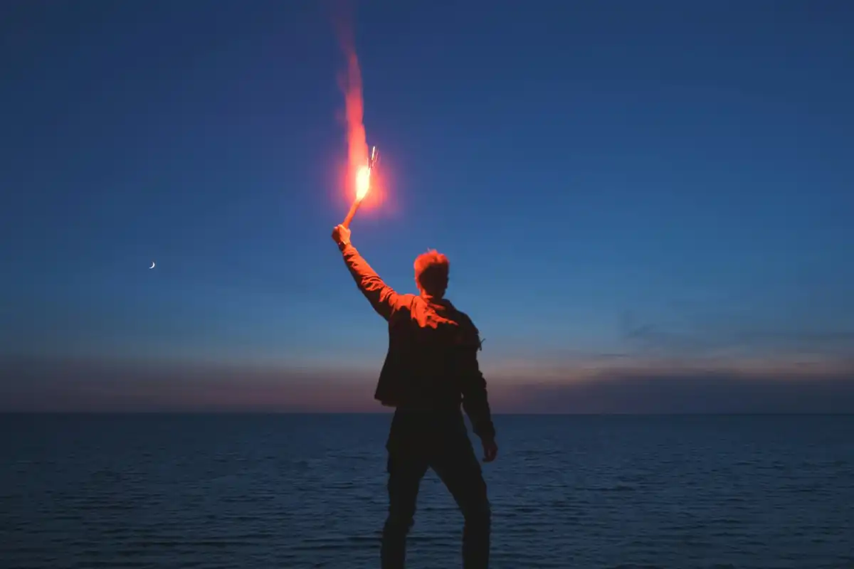 Mann mit Fackel auf Klippe