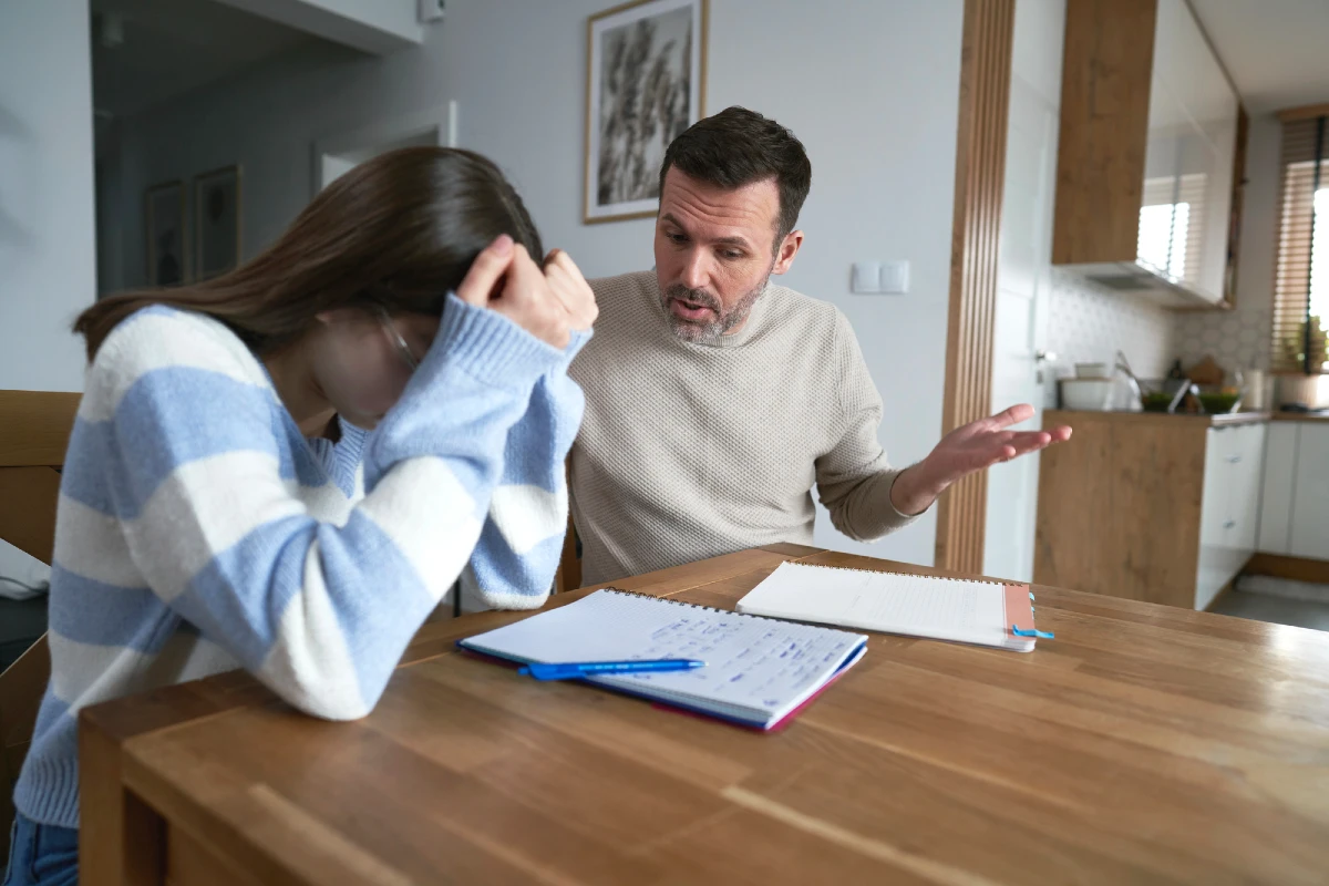 Vater spricht mit seiner Tochter am Tisch – Konflikt und Kommunikation in der Pubertät